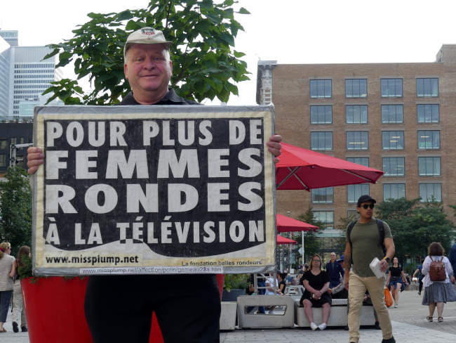 Jos Breton devant l'entre de Place des arts Montral manifestant sur la rue Ste-Catherine vers Place ville-Marie pour plus de femmes rondes  la tlvision au gala des prix gmeaux 2023.