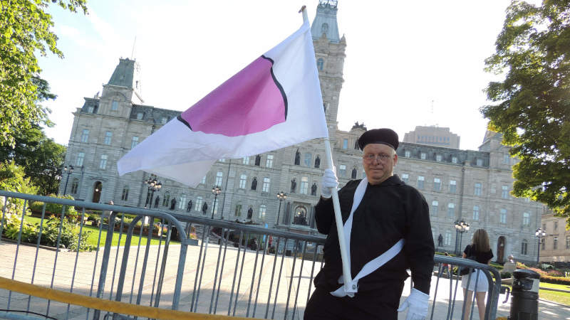 Devant le parlement du Qubec avec le drapeau de la fiert ronde.