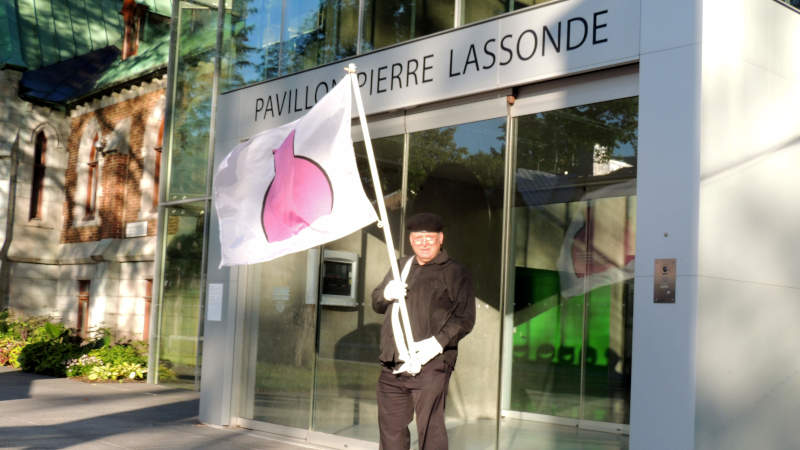 Je marche avec mon drapeau de la fiert ronde devant le Pavillon Pierre-Lassonde.