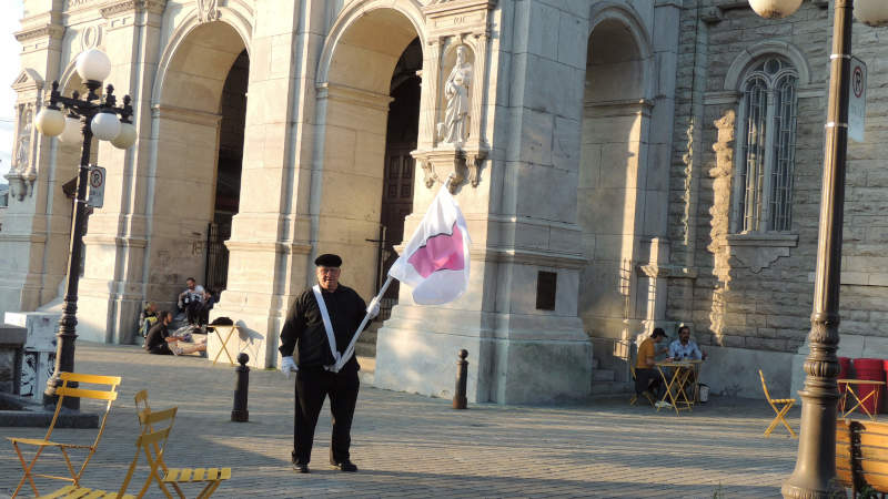 Je marche avec mon drapeau de la fiert ronde devant glise Saint-Jean-Baptiste.