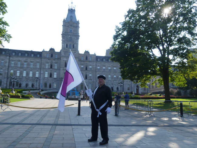 Devant le parlement du Qubec avec le drapeau de la fiert ronde.