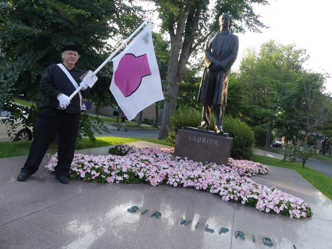 Je marche avec mon drapeau de la fiert ronde devant la Statue de Sir Wilfrid Laurier.